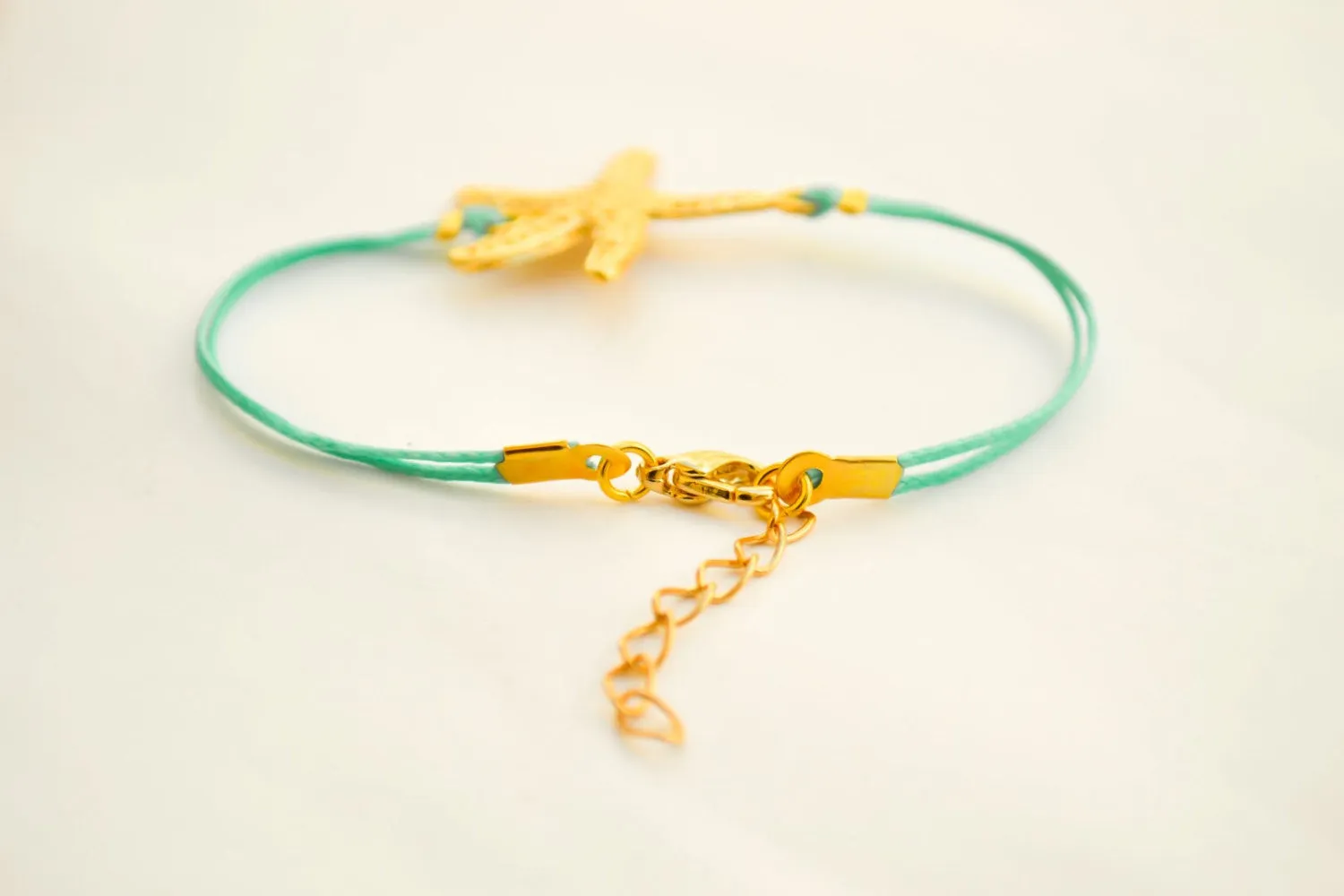 Turquoise cord bracelet with a gold starfish charm
