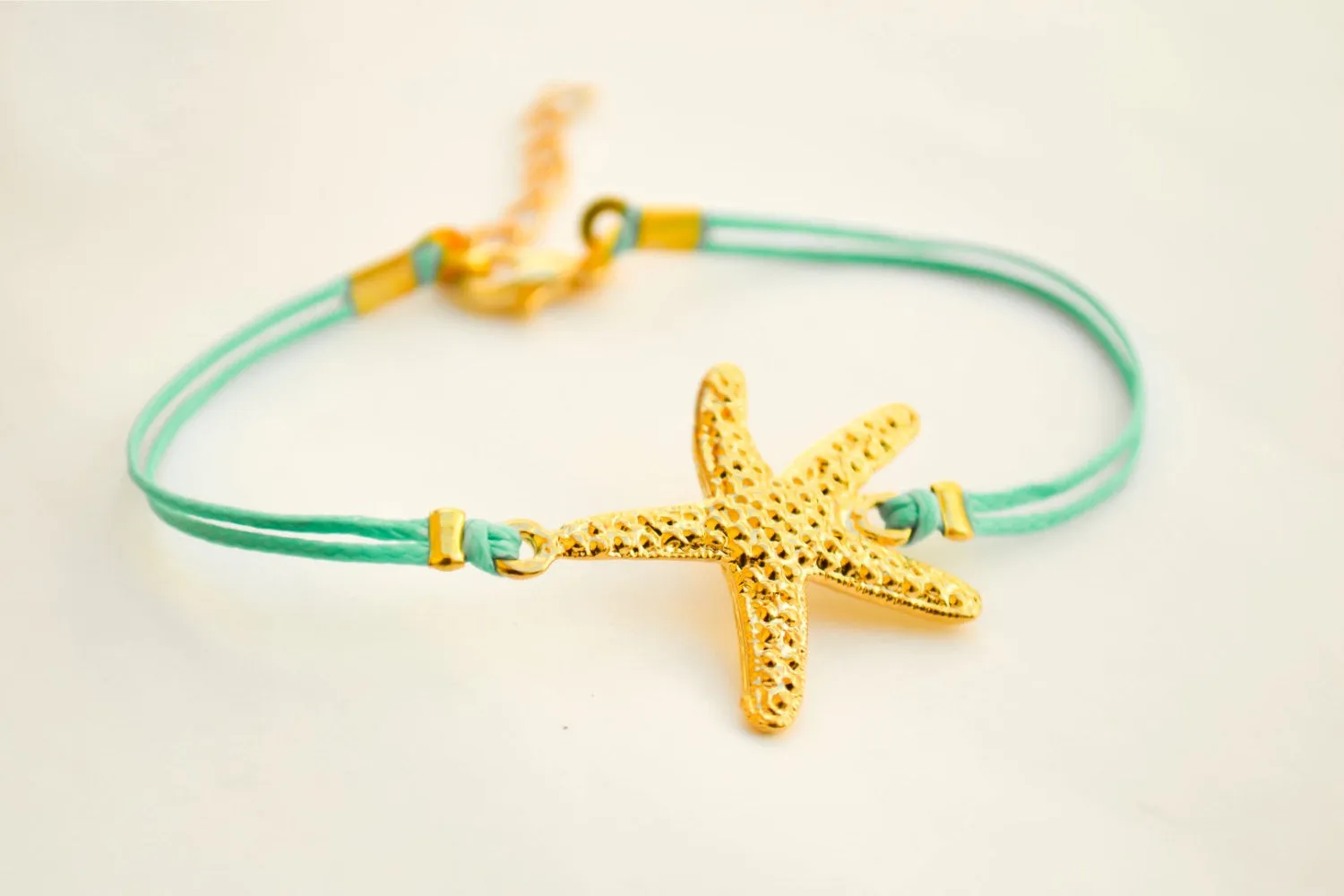 Turquoise cord bracelet with a gold starfish charm